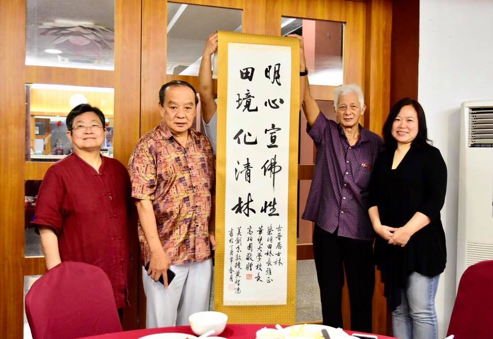 感念古晉佛教居士林蔡明田林長(左二)，在百忙之中抽空安排並全程陪同本校交流團拜訪各校，高柏園校長特請中文系王隆升教授題字、美術與文創系黃智陽教授揮毫對聯字軸乙幅，由陳娟珠主任代表學校贈與蔡林長。