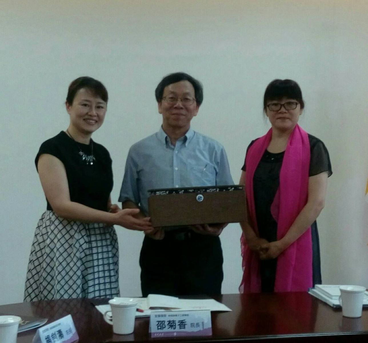 宜賓學院藝術設計學院楊劍濤院長(左)及物理與電子工程學院邵菊香院長(右)致贈本校紀念品，由簡江儒主任秘書代表接受。