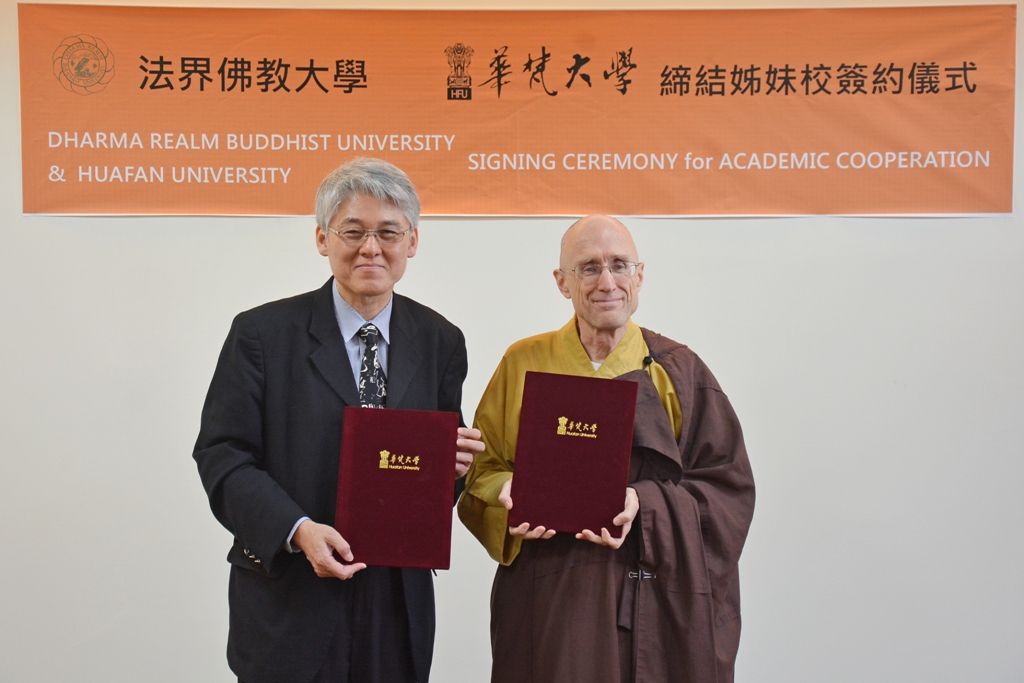 華梵大學高柏園校長(左)與法界佛教總會董事長恆實法師(右)交換姊妹校合約書。