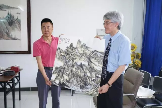 天津理工大學藝術學院趙新華院長(左)致贈高校長該校萬禹辰老師國畫作品。