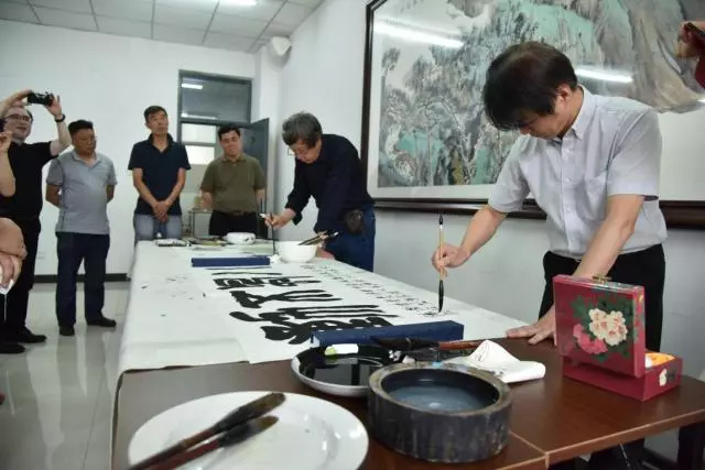 藝術設計學院院長黃智陽教授(右)與該校藝術學院副院長王春濤教授(中)進行現場筆會。